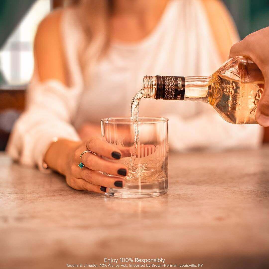 Close-up photo of tequila poured into woman's glass