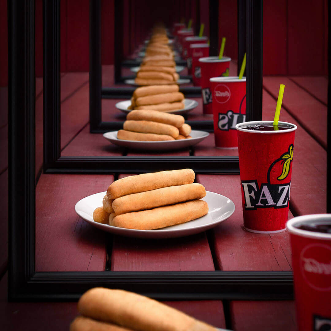Infinite mirror effect featuring endless plates of breadsticks next to soda cups 